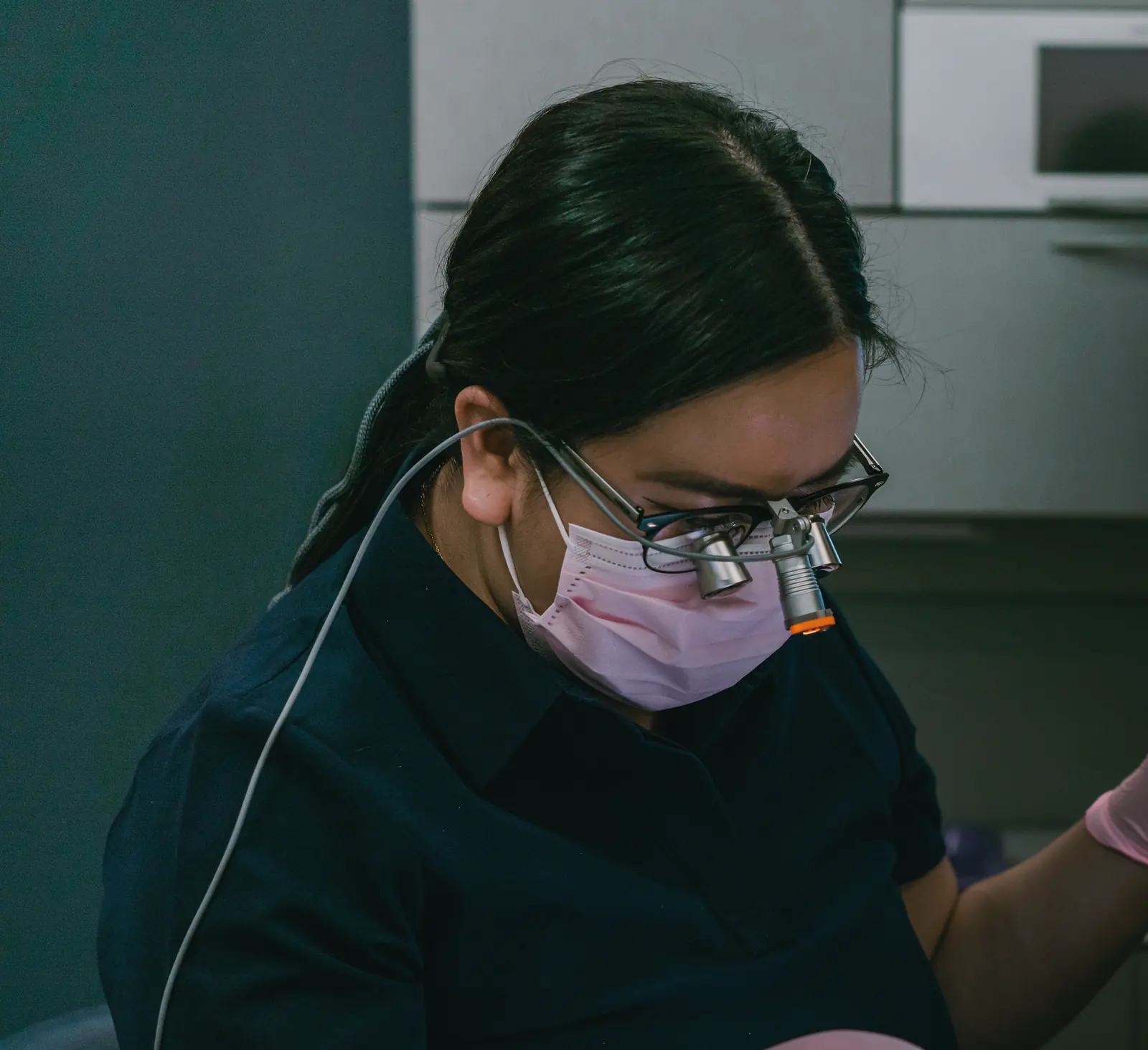 Dr. Katherina Nguyen, DDS, at work in magnifying loupes and a headlight