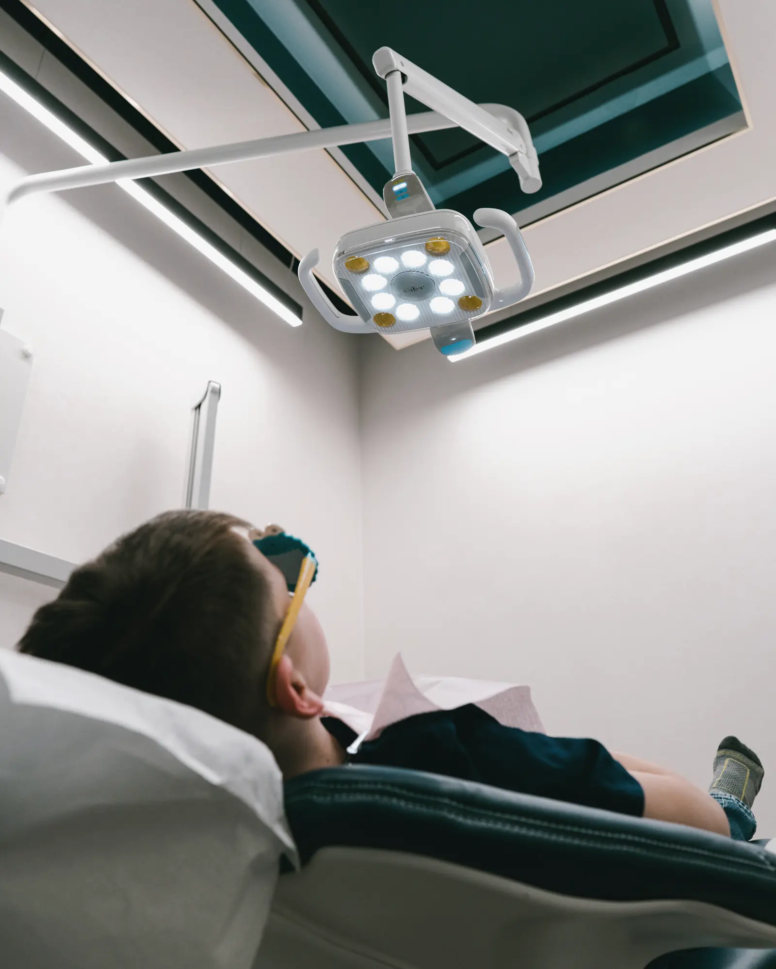 Treatment room with a teal and gold ceiling and a patient relaxing in the chair