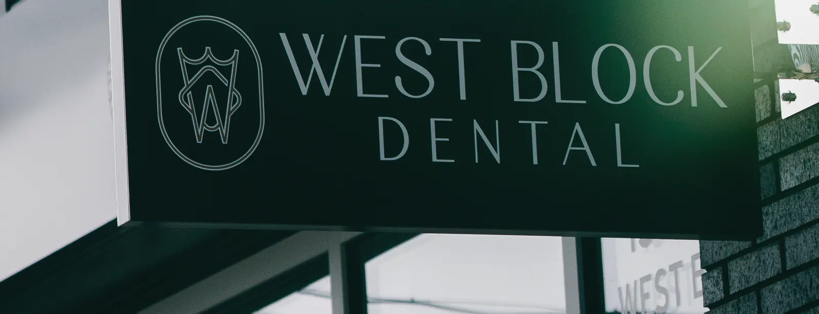 West Block Dental hanging sign at the clinic entrance on West Block Drive NW